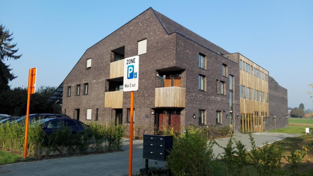 Modern appartementencomplex met parkeerzone bord.