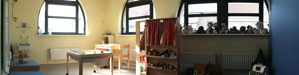 Speelkamer met poppen en speelgoed.
